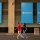 A couple walks past a Barclays logo in Johannesburg